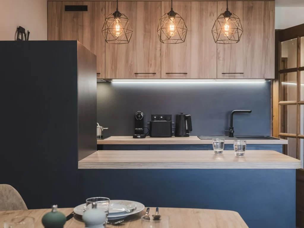 Conception d'une cuisine en bois et gris anthracite avec une table à manger par Marjolaine Berthet Interior Design, Architecte d'intérieur à Chamonix 74